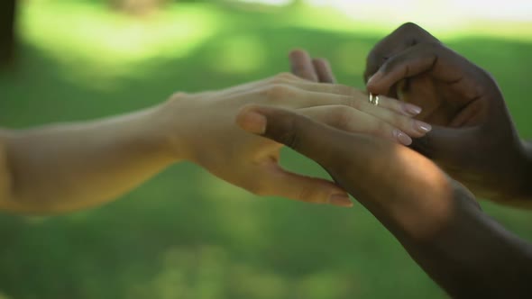 Multiracial Marriage, Male Hand Puts Golden Ring on Brides Finger, Wedding Time
