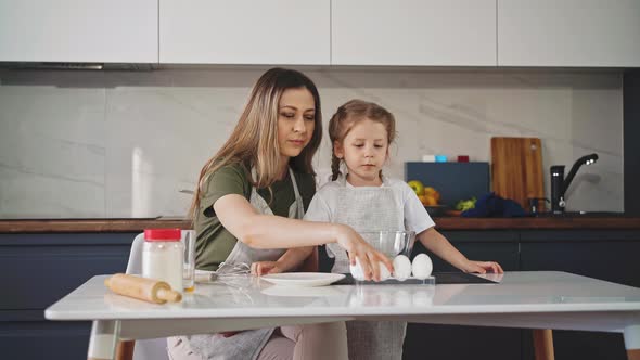 Mother and Young Daughter in Kitchen Prepare Food
