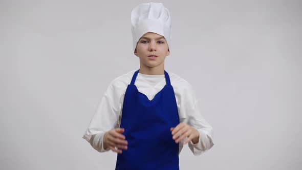 Stressed Little Cook Rubbing Temples Pulling Chef Hat on Head