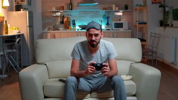 Focused Man Holding Joystick While Sitting in Front of Television