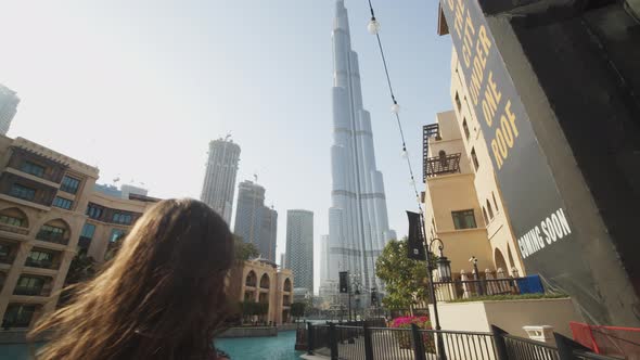 Woman Watching Burj Khalifa Skyscraper By the Pool in Dubai