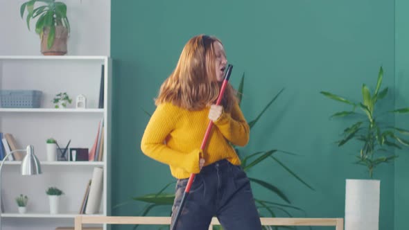 Happy Young Girl Student in Headphones Dancing and Singing on the Bed