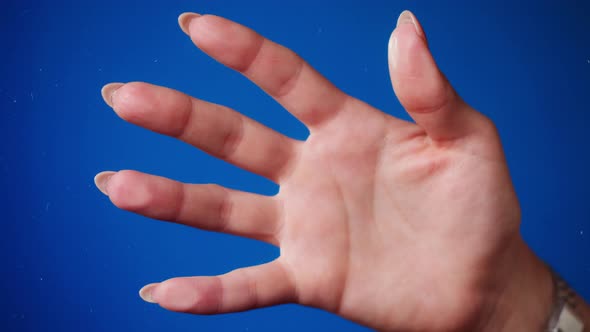 Female Human Hand Making Fingerprints on Blue Background
