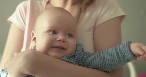 Portrait of Cutie Baby Smiling at Camera on Mother's Hands