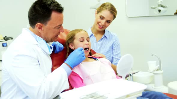 Dentist examining a young patient with a tool
