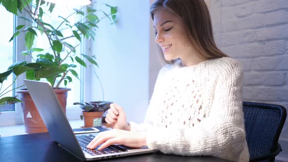Web Video Chat on Laptop By Young Female Sitting In Office