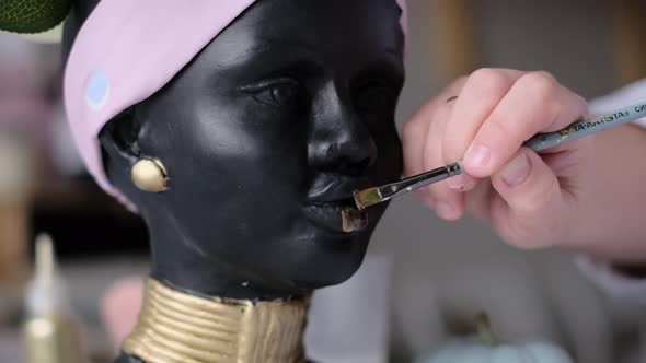 Woman Decorates a Vase in the Form of a Plaster Bust