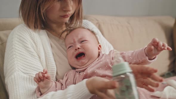 Mom Giving Water to Crying Baby