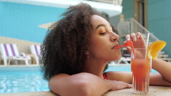 Afroamerican Lady on Journey Summer Vacation Bathing in Maldives Hotel Pool Drink Luxury Juice