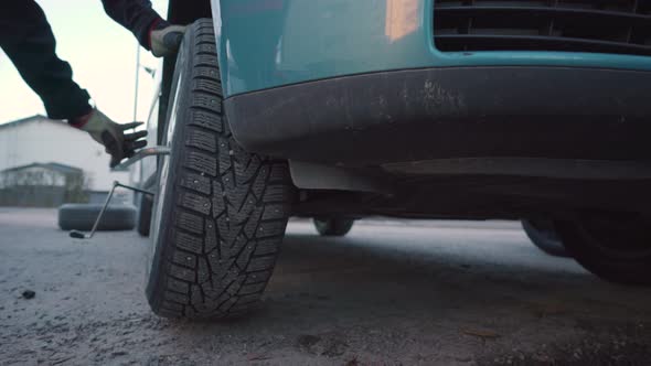 Man taking off a tyre from a car. Tyre changing process