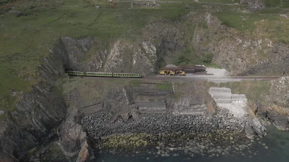 Train Coming Out From A Tunnel At Headland In Bray - Bray Head Tunnel In Ireland. - aerial