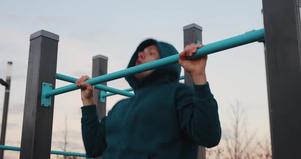 Athletic Man Doing Pullups on the Bars