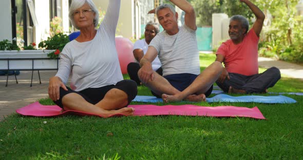 Senior friends doing exercise in garden 4k