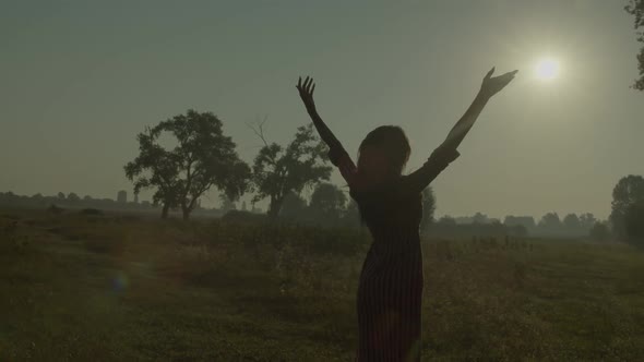 Joyful Lovely Black Woman with Open Arms Standing Under Sunrise in Nature