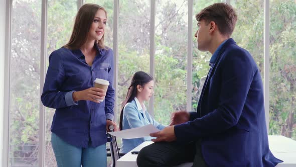 Happy Businesswoman and Businessman Having Conversation in Modern Office