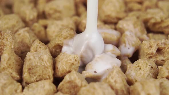 Pouring and splashing milk on dry quick healthy breakfast cereals