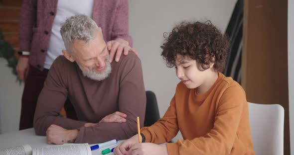 Gay Step Parents Watch Son Student Doing Homework at Table