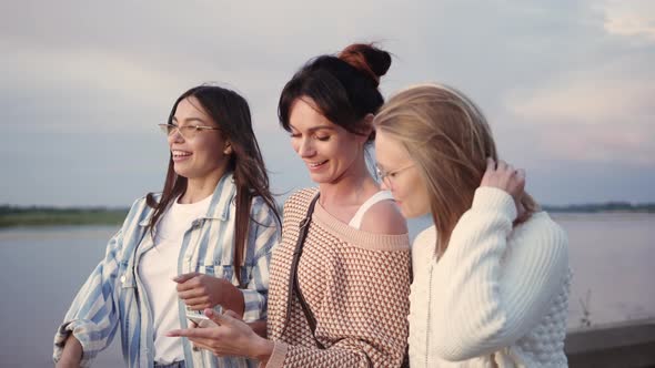 Women Using a Smart Phone Outdoors Looking Very Happy.