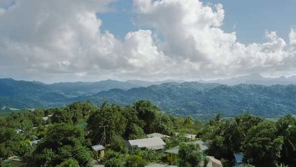 Drone camera moves over the settlement to the cliff on Saint Lucia