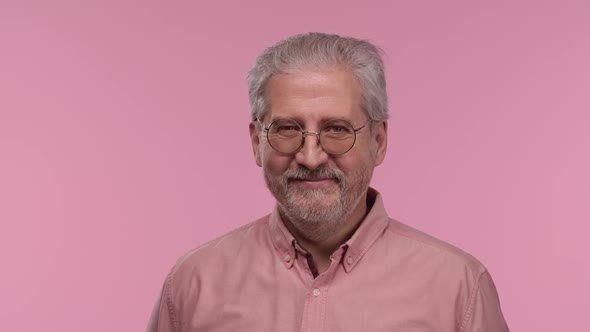 Portrait of an Elderly Man with Glasses Looking at Camera and Smiling