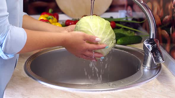 Closeup of Young Woman Washing Fresh Cabbage in Sink Under Running Water