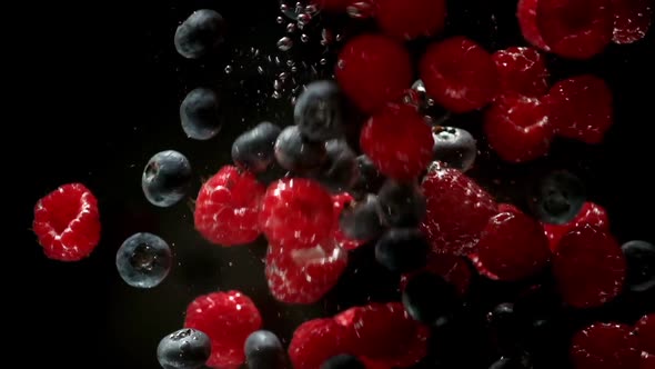 Berry. Raspberry, blueberry and mulberry falling into transparent water