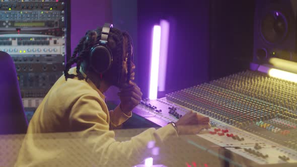 African American Man Using Mixing Console in Recording Studio