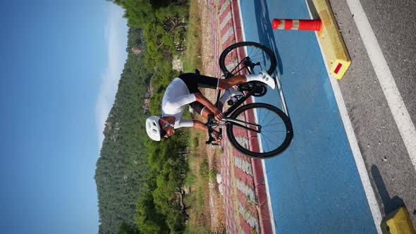 Man speeding and sprinting on sport race bicycle along cycle path. Vertical video.