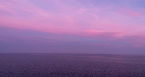 4k drone video flight over ocean, sea at beautiful purple sunset. Close to the water