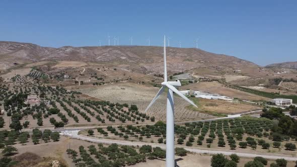 Wind turbine generating sustainable energy for European farm, wind farm backdrop