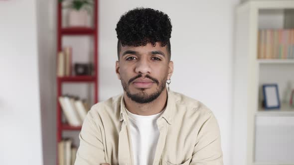 POV of Serious Latin American Hispanic Young Man Listening on Video Call at Home