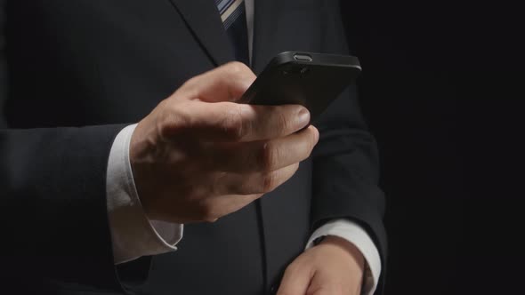 Businessman Holds A Smartphone By Hand And Types On It