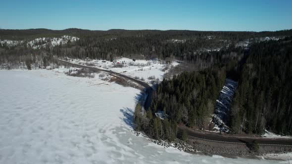 Aerial Over a Winter Lake Onega in Northwestern Russia Road Next to a Lake in the Countryside