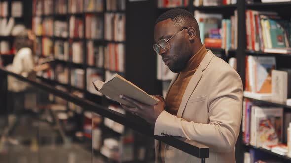 African American University Professor Reading Book in Library