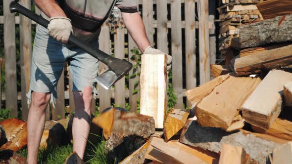 Strong Male Worker Chopping Wood Swinging and Hitting Wooden Log with Axe