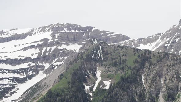 Panning view of mountain top with melting snow.