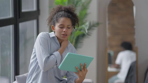 Young Confident African American Woman Using Virtual Conference on Tablet with Blurred Reflection of