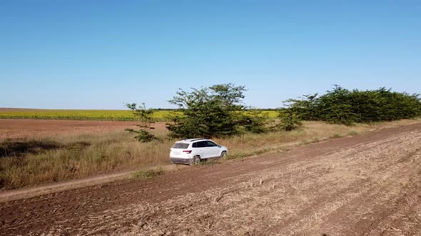 White Car is Driving on a Rural Road