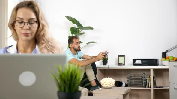 Noisy Boyfriend Plays Video Game While Freelancer Girlfriend Is Working at Home