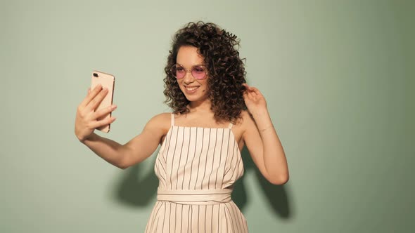 Beautiful smiling model with afro curls hairstyle dressed in hipster clothes