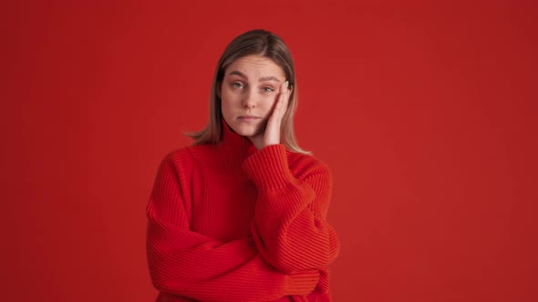 Bored woman wearing red sweater looking at the camera