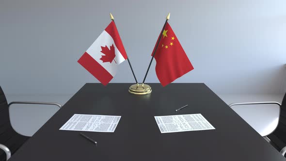 Flags of Canada and China and Papers on the Table alt