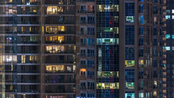 Glowing Windows in Multistory Modern Glass Residential Building Light Up at Night Timelapse