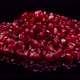 Heap of pomegranate grains. Red seeds of grenade rotating on a black background. - VideoHive Item for Sale