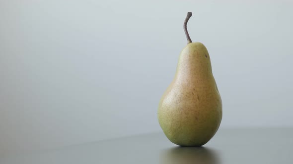 Close-up of single fruit from genus Pyrus 4K 2160p UltraHD tilting footage - Organic pear with pedun