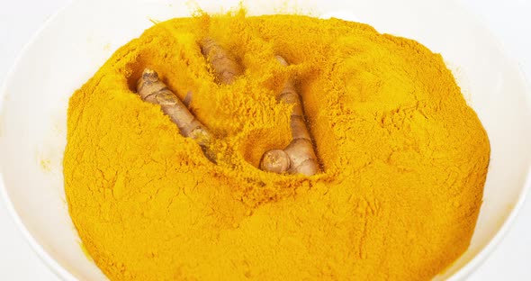 Turmeric, curcuma longa, Root falling on curcuma Powder, Indian Spice, Slow Motion 4K