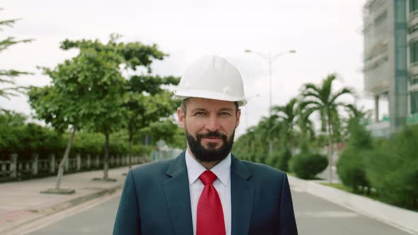 Portrait Senior Industrial Engineer in Business Suit White Safety Helmet Looking Directly Into the