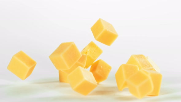 Super Slow Motion Shot of Cheese Chunks Falling on White Background at 1000 Fps.
