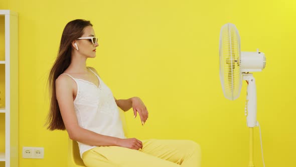 Young Woman Is Chilling Out In Front of Electric Fan