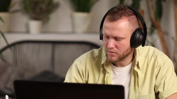 Man wearing wireless headphones watch webinar, trainning